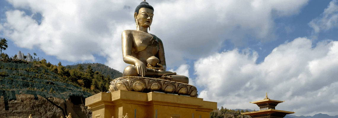 A vajrayana temple featuring a giant golden buddha on top of the roof