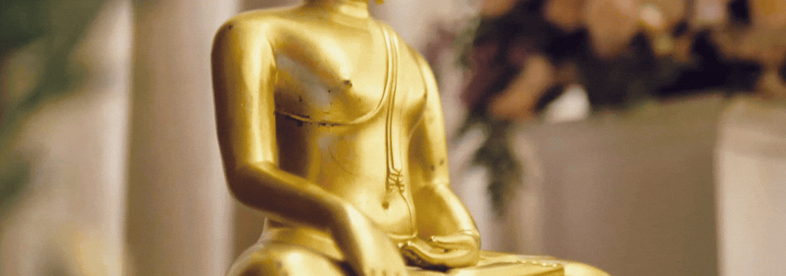 A rather handsome gold buddha statue is looked up and down